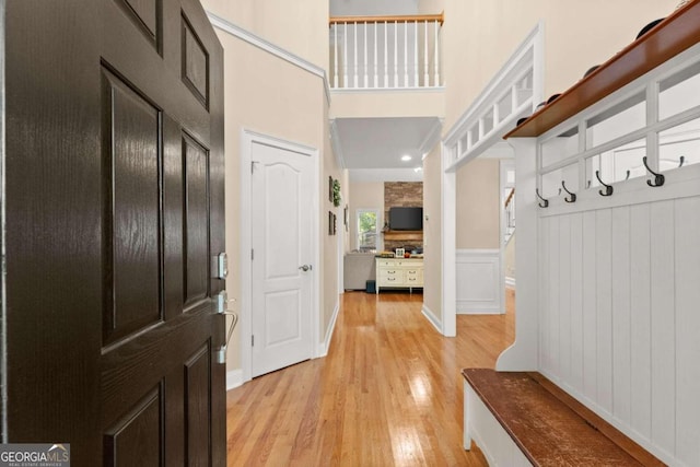 mudroom with light wood-type flooring and a high ceiling