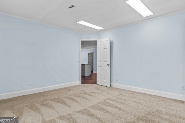 carpeted empty room featuring crown molding