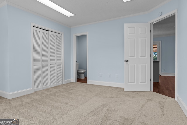 unfurnished bedroom with carpet floors, a closet, and ornamental molding