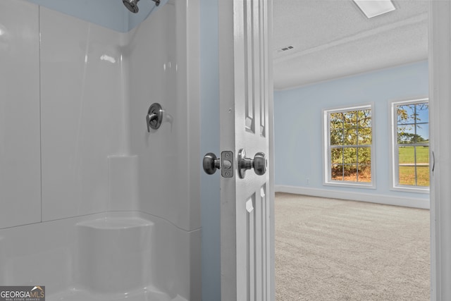 bathroom featuring walk in shower and a textured ceiling