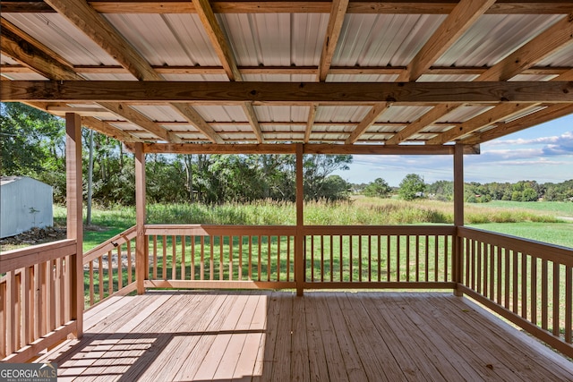 wooden deck with a storage shed and a yard