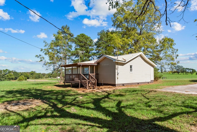 rear view of house with a lawn and a deck