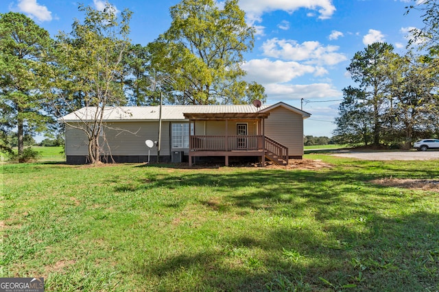 back of property with a yard and a wooden deck