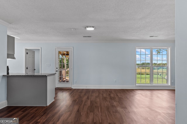 unfurnished living room with ornamental molding, a textured ceiling, and dark hardwood / wood-style flooring