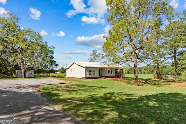 view of front of property featuring a front yard and a storage unit