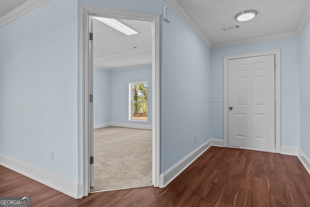 corridor with a textured ceiling, crown molding, and dark hardwood / wood-style flooring