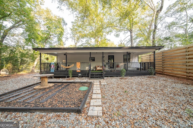 rear view of property featuring a wooden deck