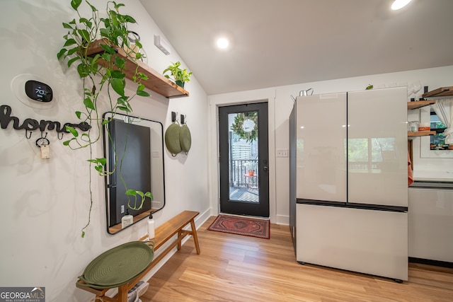 foyer with light hardwood / wood-style flooring and vaulted ceiling