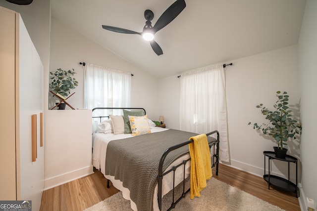 bedroom with vaulted ceiling, hardwood / wood-style flooring, and ceiling fan