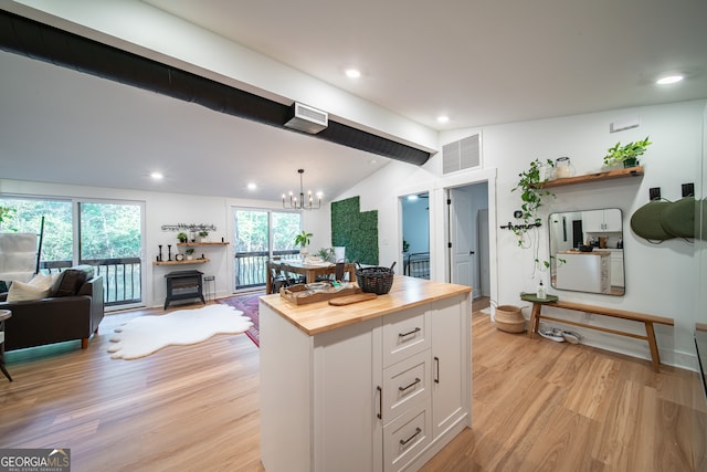 kitchen featuring hanging light fixtures, light hardwood / wood-style flooring, white cabinetry, an inviting chandelier, and butcher block counters