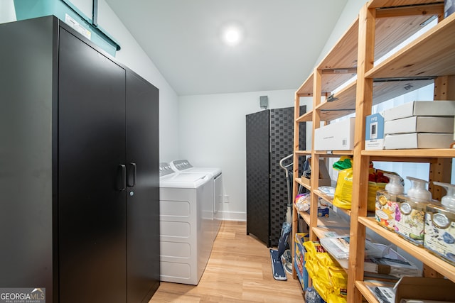 clothes washing area featuring washer and dryer and light hardwood / wood-style flooring