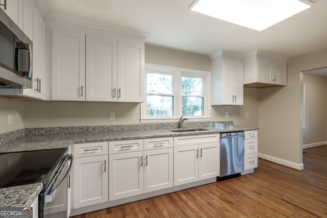 kitchen with stainless steel appliances, wood-type flooring, white cabinets, and sink