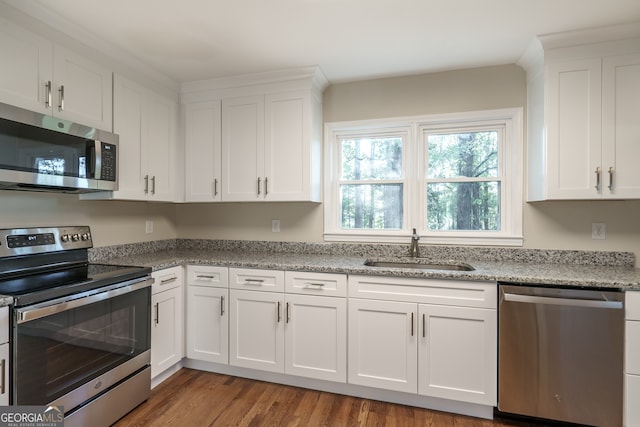 kitchen with white cabinetry, appliances with stainless steel finishes, sink, and hardwood / wood-style flooring