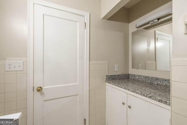 bathroom with vanity and tile walls