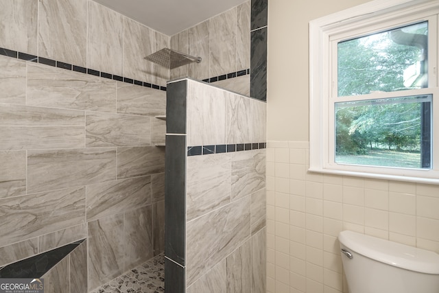 bathroom featuring plenty of natural light, a tile shower, and toilet