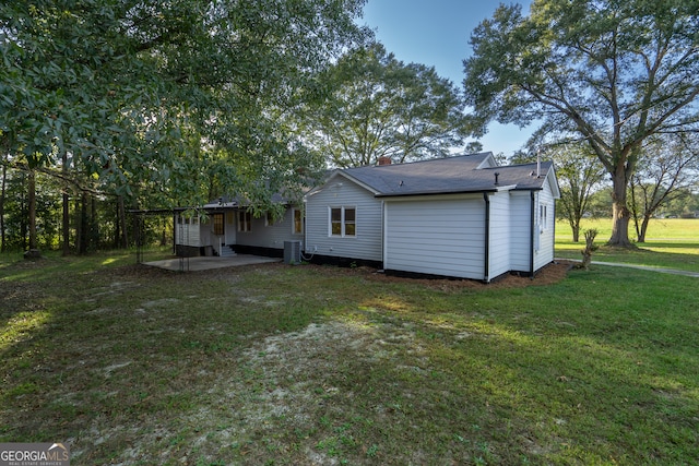 rear view of property featuring cooling unit, a yard, and a patio area