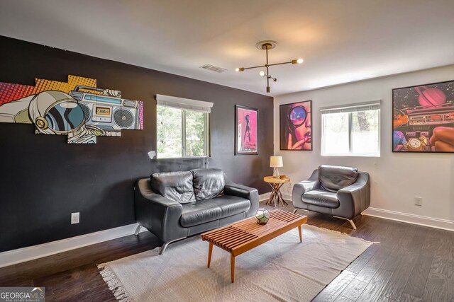 living room featuring a notable chandelier, dark hardwood / wood-style floors, and plenty of natural light