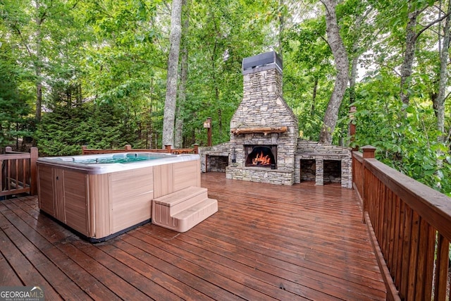 deck with a hot tub and an outdoor stone fireplace