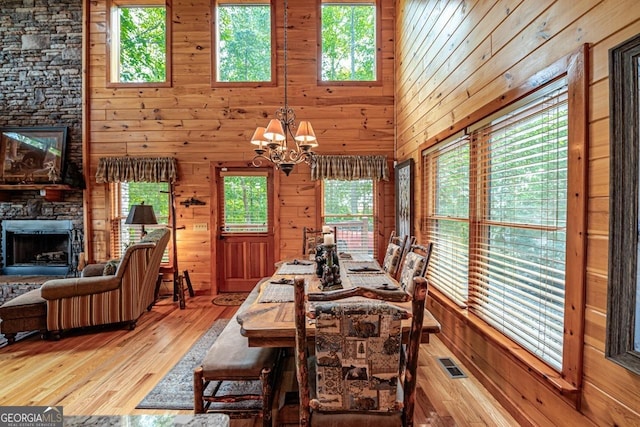 dining space featuring wooden walls, a healthy amount of sunlight, and a high ceiling