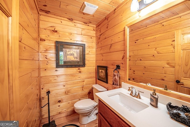 bathroom with vanity, toilet, wood ceiling, and wooden walls