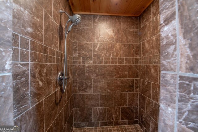 bathroom with wooden ceiling and tiled shower