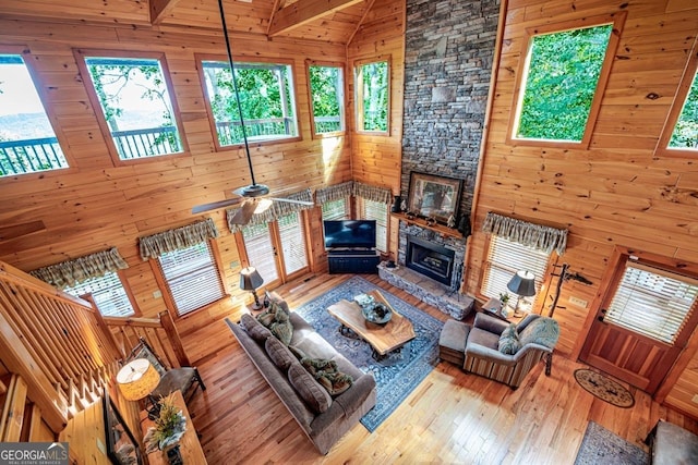 living room with beam ceiling, a wealth of natural light, high vaulted ceiling, and ceiling fan