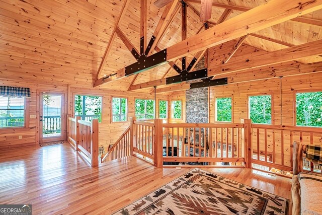 interior space with light hardwood / wood-style flooring, high vaulted ceiling, wooden walls, and wood ceiling