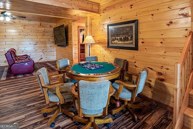 game room with dark hardwood / wood-style floors, ceiling fan, and wooden walls