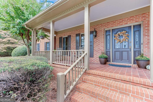 view of exterior entry featuring covered porch