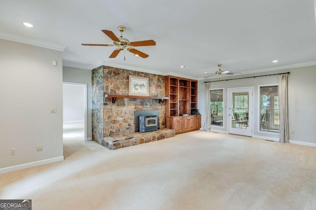 unfurnished living room with ceiling fan, light carpet, crown molding, and a wood stove