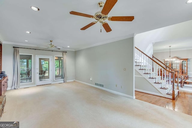 unfurnished living room featuring ceiling fan with notable chandelier, crown molding, and light hardwood / wood-style flooring