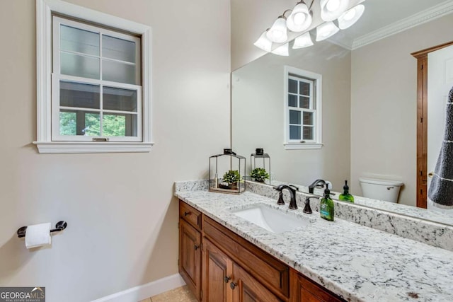 bathroom with crown molding, vanity, and toilet