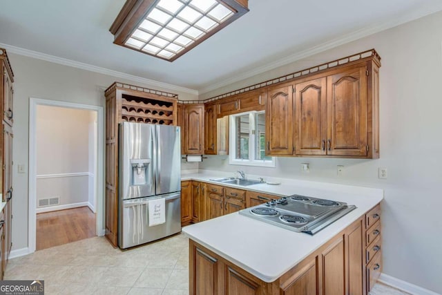 kitchen with light tile patterned floors, sink, ornamental molding, kitchen peninsula, and stainless steel appliances