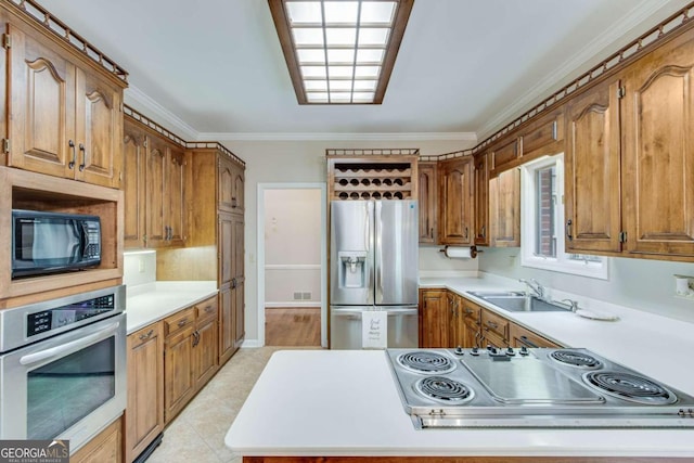 kitchen featuring stainless steel appliances, crown molding, and sink