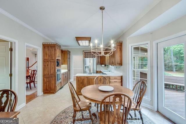 tiled dining area featuring ornamental molding, an inviting chandelier, and sink