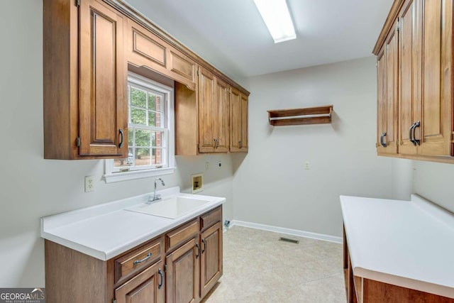 clothes washing area with washer hookup, cabinets, and sink