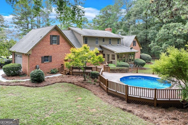 back of property featuring a yard and a swimming pool side deck