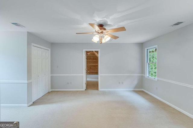 spare room featuring ceiling fan and light carpet