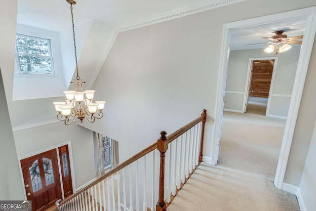 interior space featuring ornamental molding, light carpet, and a notable chandelier