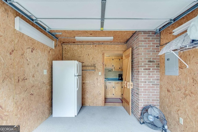 garage with white refrigerator and electric panel