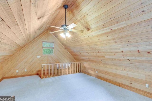 additional living space featuring ceiling fan, vaulted ceiling, wood walls, and wooden ceiling