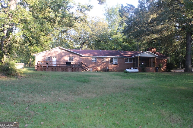 back of house with a wooden deck, a sunroom, and a yard