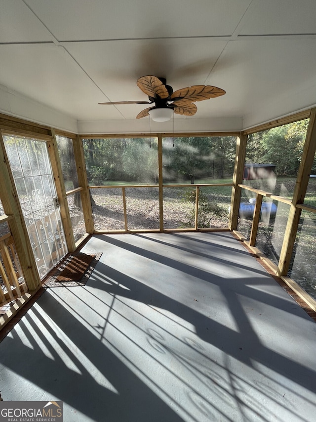 unfurnished sunroom featuring ceiling fan