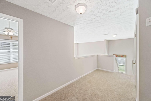 corridor featuring carpet floors and a textured ceiling