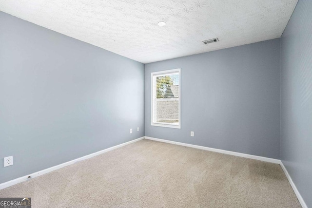 carpeted spare room with a textured ceiling