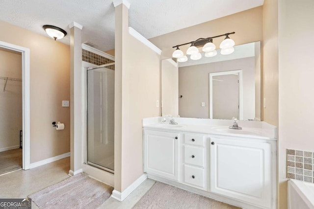 bathroom with vanity, plus walk in shower, and a textured ceiling