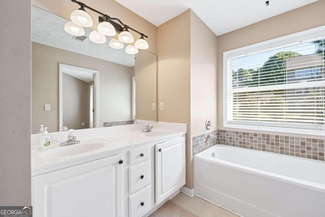 bathroom with tile patterned flooring, a bathtub, vanity, and a textured ceiling