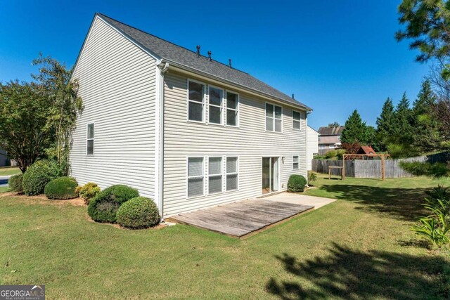 rear view of property featuring a yard and a deck