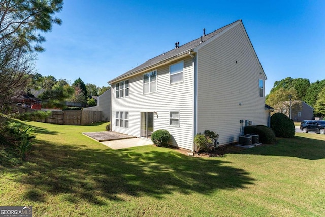 rear view of house featuring a lawn and a patio