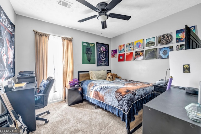 bedroom featuring a textured ceiling, carpet floors, and ceiling fan